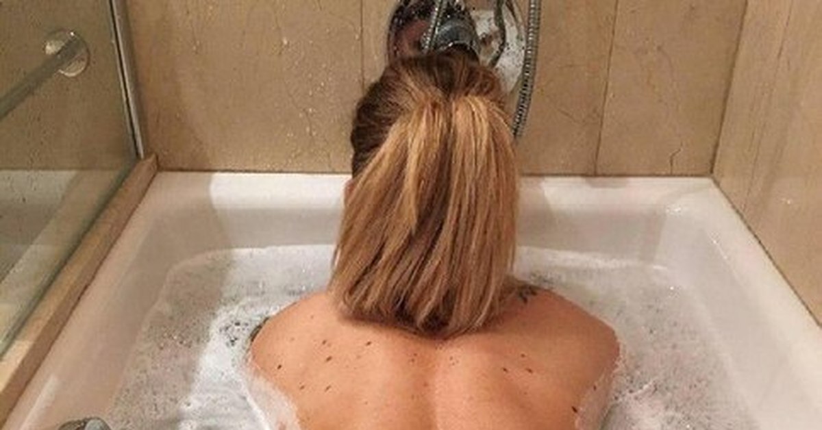 Рыжеволосая женщина шалит в ванне