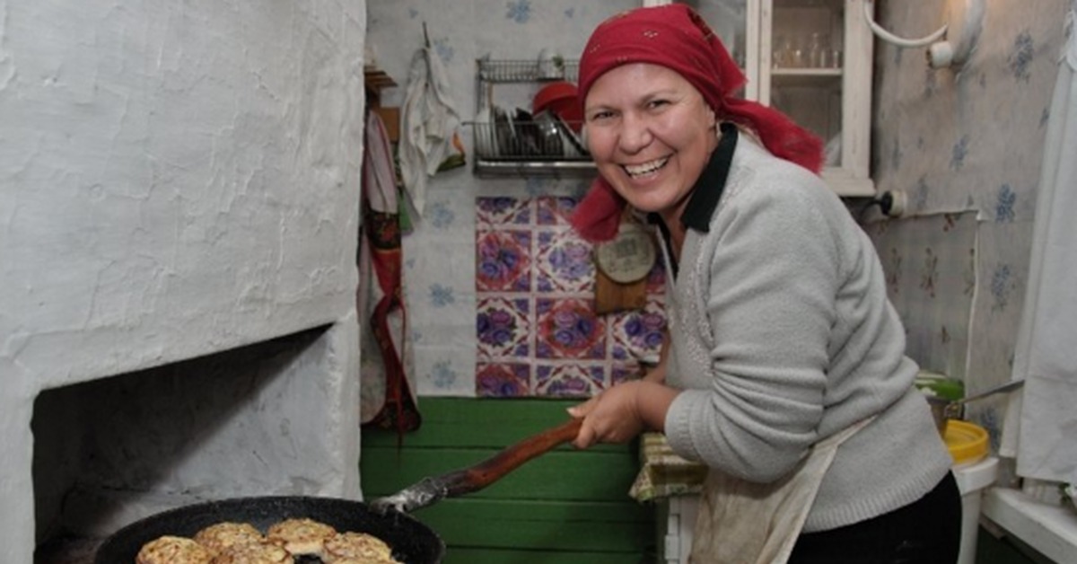 Бабушка одевает внука пельмени. Бабушка на кухне. Бабушка готовит. Бабушка с котлетами. Женщина печет.