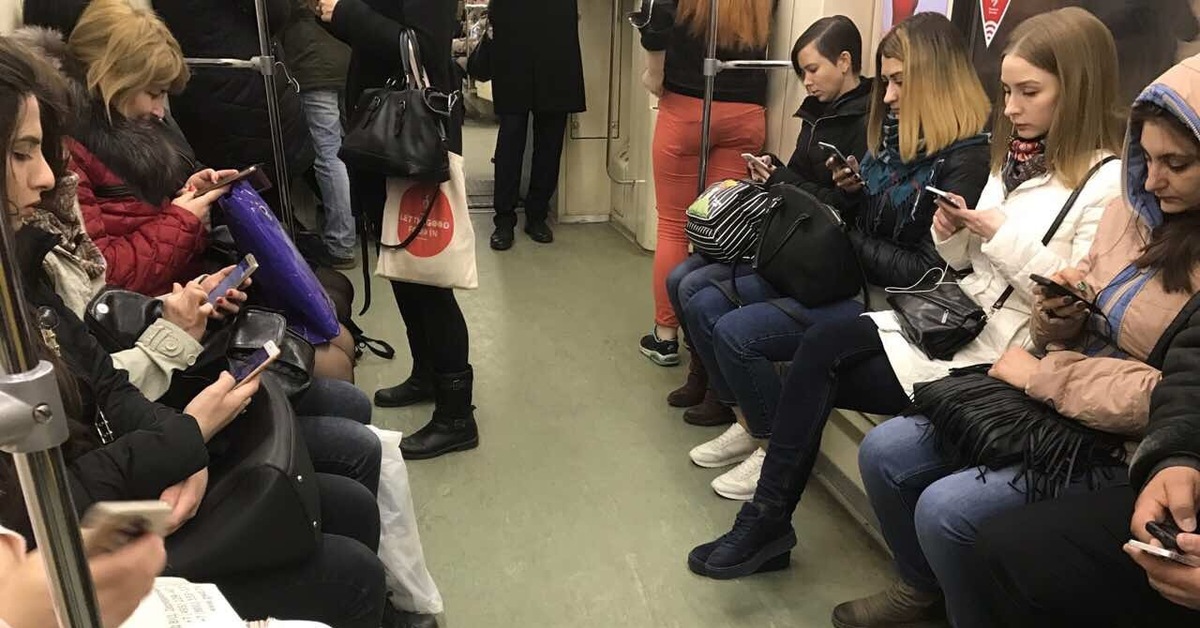 Она читает в метро. Люди с телефонами в метро. Люди со смартфонами в метро. Человек сидит в метро. Человек в транспорте и смартфон.
