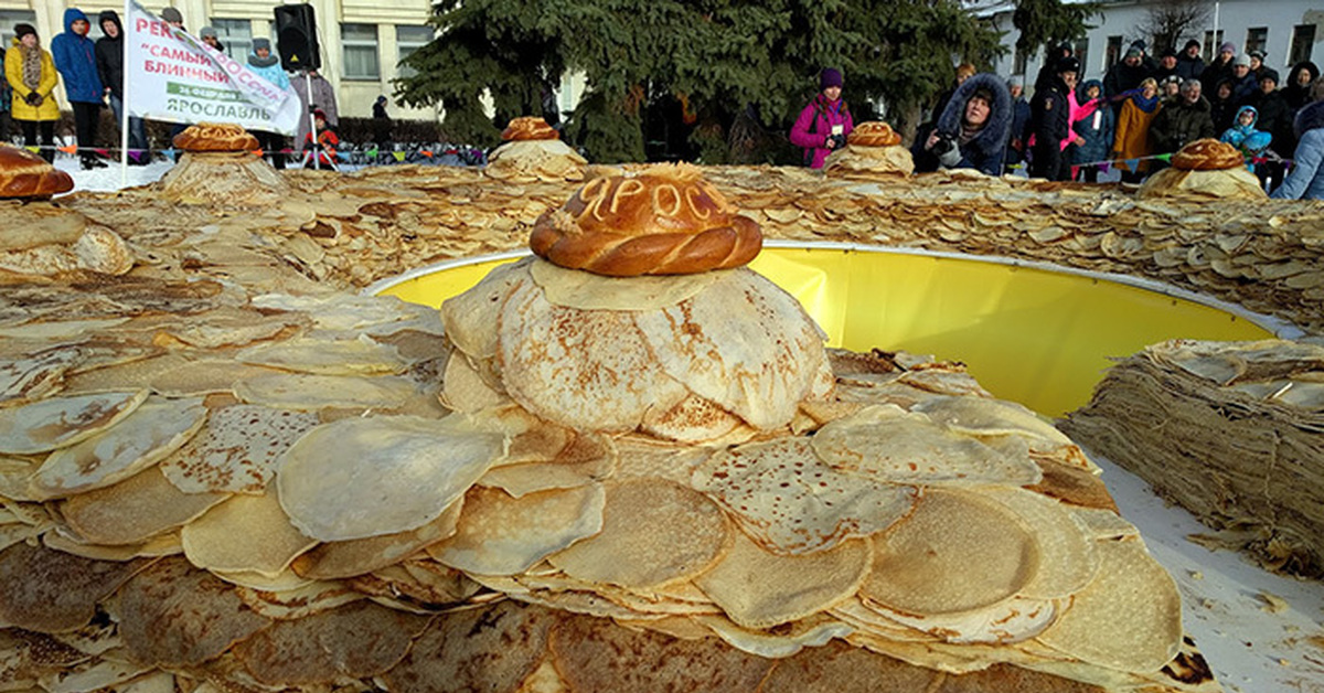 Большой пирог. Гигантский блин. Огромная куча блинов. Много блинов на Масленицу. Огромный блин на Масленицу.