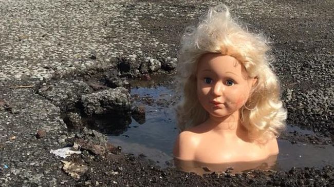 'Queen of the Pit': British man covers holes in the road with doll heads - Road, England, Potholes, Creative, Creative solution