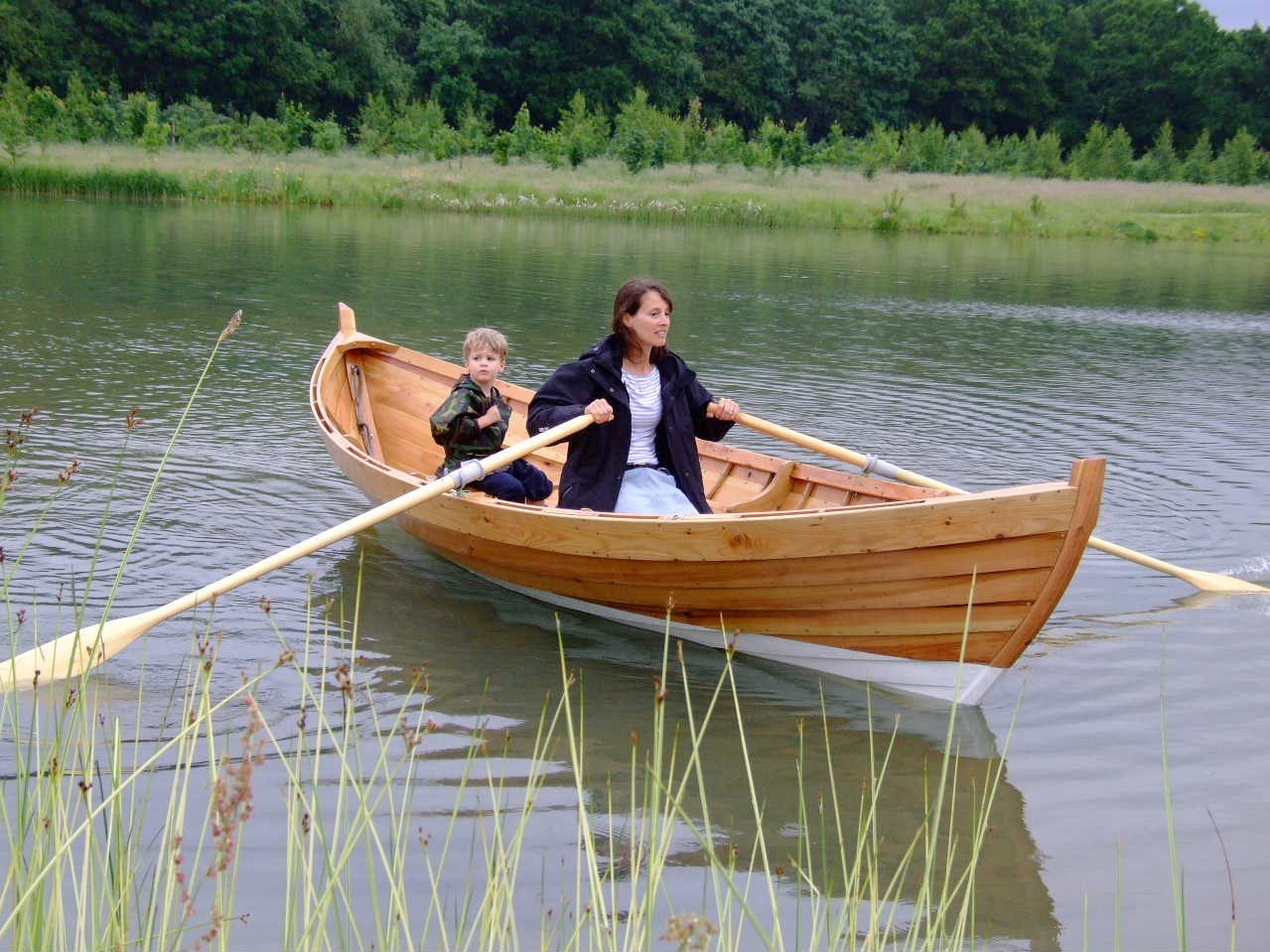 Люди в шлюпке. Гребная лодка «Флит-15». Лодка с веслами. Деревянная ложка-весло. Лодка деревянная с веслами.