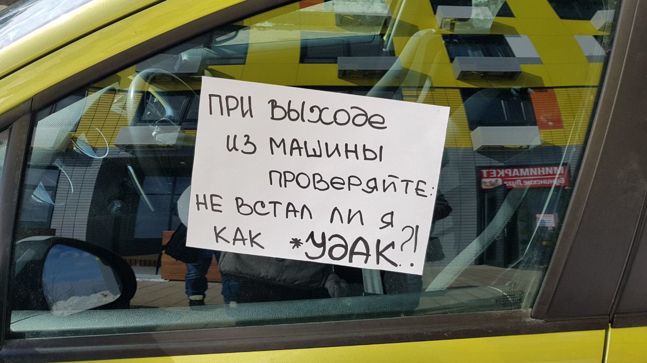 На парковке водители расставили свои автомобили. Надписи за неправильную парковку. Подперли машину. Убери машинку. Не паркуйте машину.